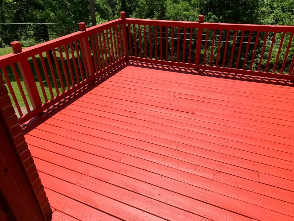 A deck freshly stained in a bright barn-red finish